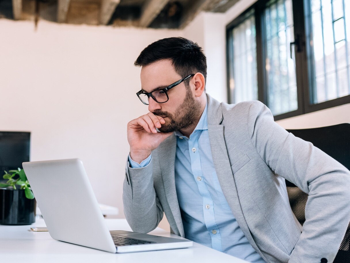 Inversionista internacional del sexo masculino mirando una computadora portátil